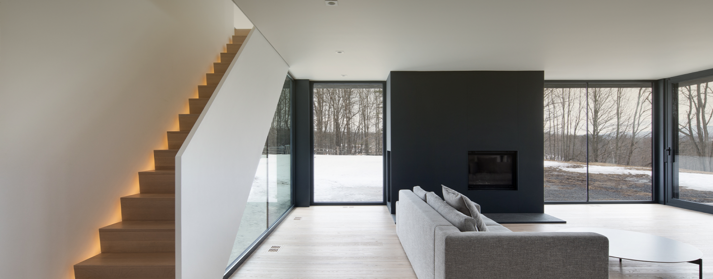 an interior view with midcentury modern furniture and northern wide wood planks on the floor